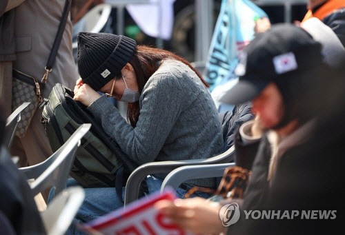헌재의 윤석열 전 대통령 탄핵 인용이 발표된 4일 서울 용산 대통령실 인근에서 한 지지자가 고개를 숙이고 있다. [연합뉴스]
